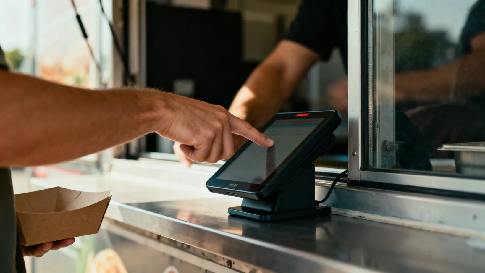 A customer giving feedback at a food truck point-of-sale terminal