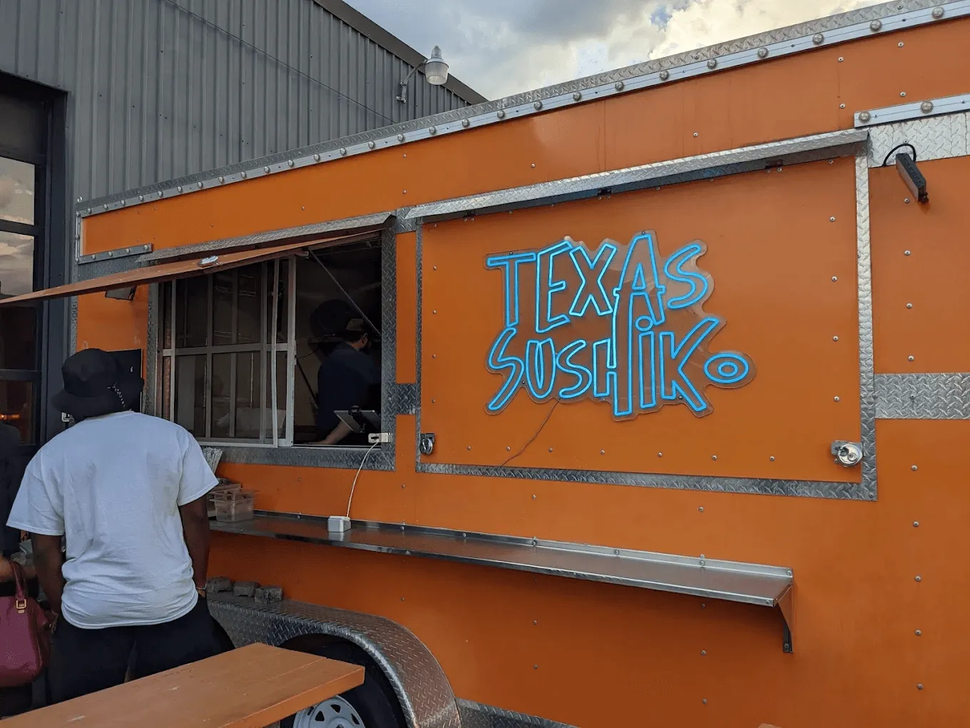 People stand in front of Texas Sushik food truck