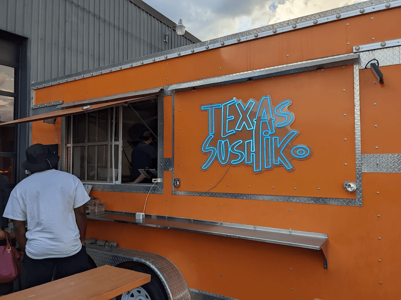 People stand in front of Texas Sushik food truck